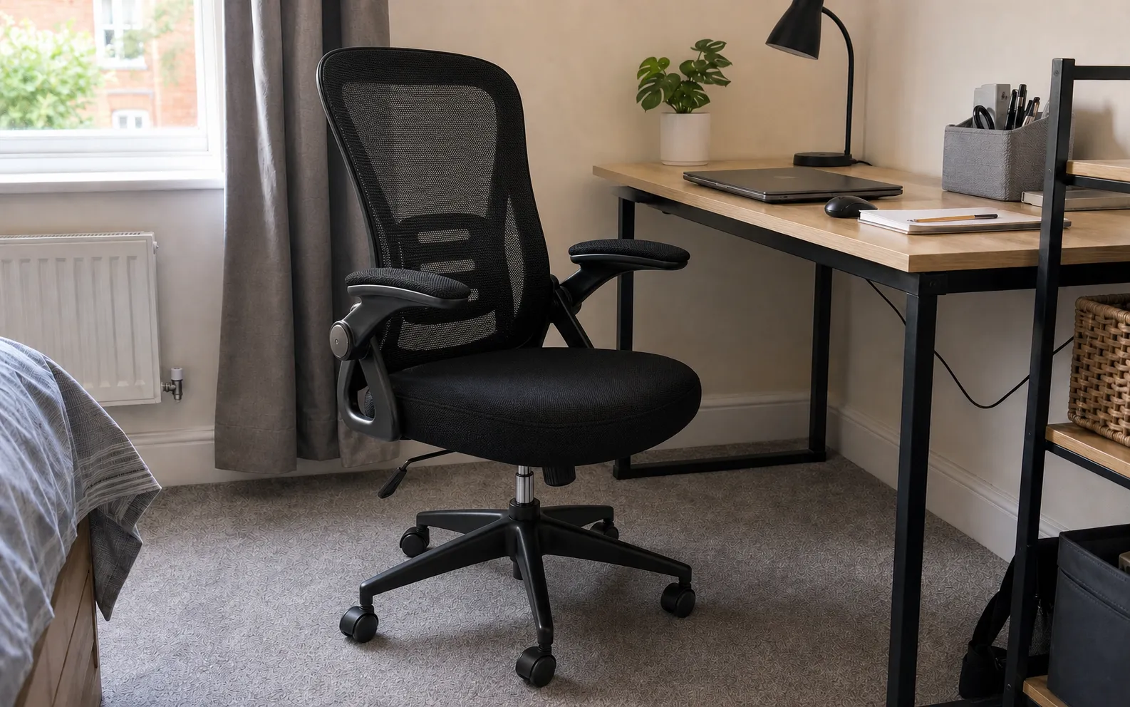 Naspaluro black mesh office chair with flip-up arms beside a compact bedroom desk